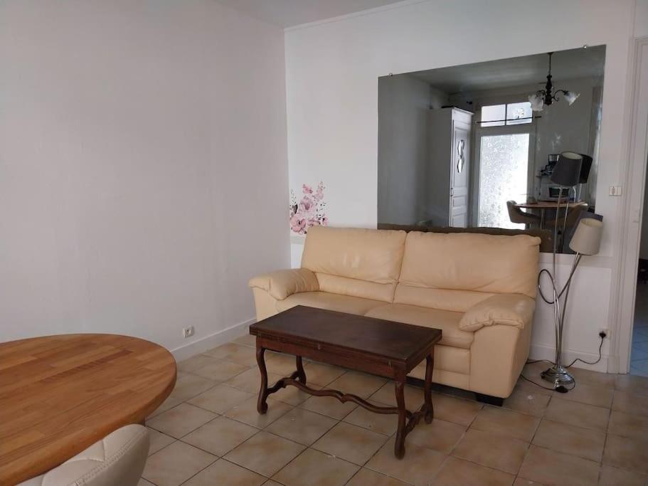 a living room with a couch and a table at Cocon calme, 2 pièces Tours proche bord de Loire in Tours