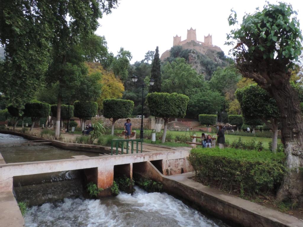 a bridge over a river with a castle in the background at Appartement au centre ville in Beni Mellal