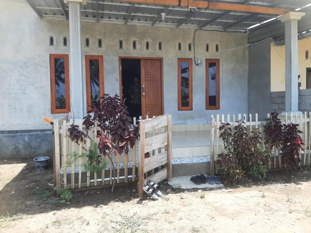 a house with a wooden fence in front of it at D'Yoga Homestay in Sewela