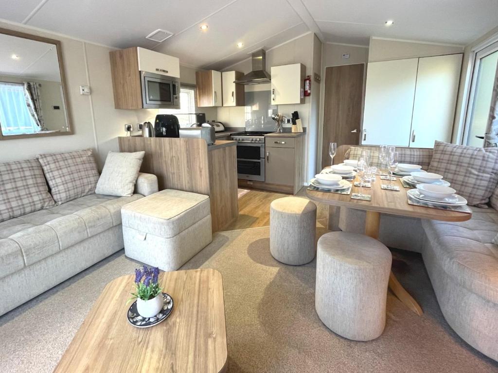 a living room with a table and a kitchen at Pass the Keys Gorgeous Home in Beautiful Kippford Country Park in Dalbeattie