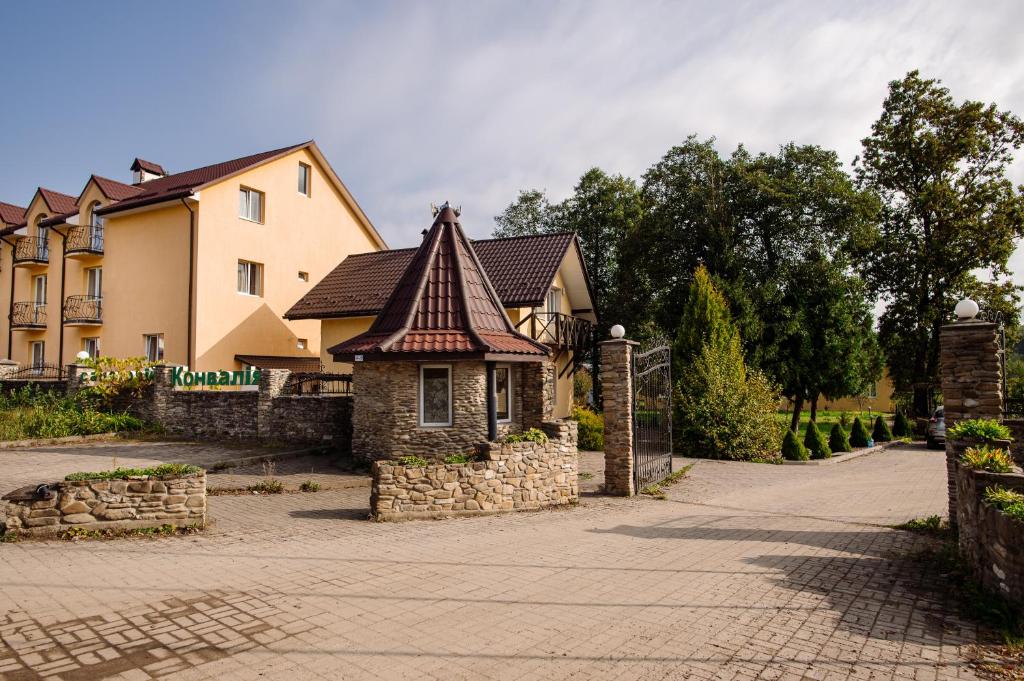 ein Haus mit einem Kacheldach und einer Ziegelsteinfahrt in der Unterkunft Hotel Konvalia in Truskawez