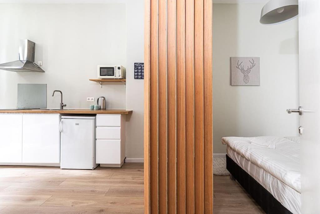 Habitación con cama y cocina con tabique de madera. en Van Lerius studio, en Amberes