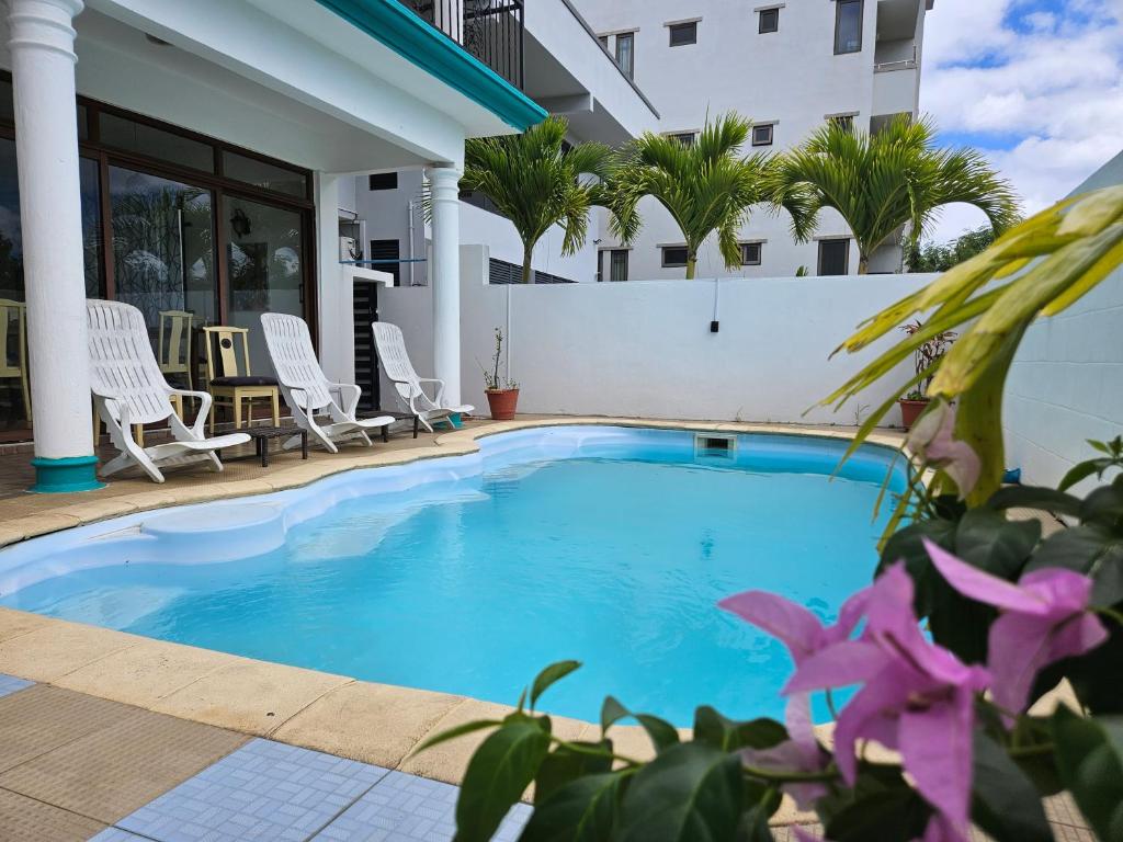 a swimming pool in front of a house at Grand Bay Apartments in Grand Baie