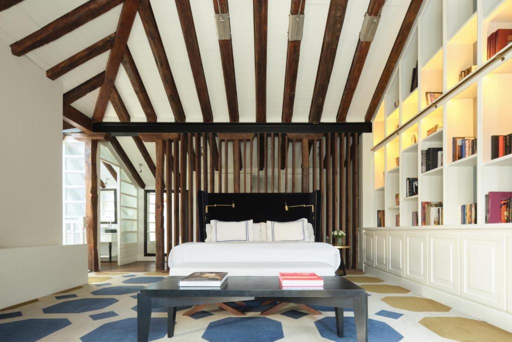 een slaapkamer met een bed, een tafel en boekenplanken bij Only YOU Boutique Hotel Madrid in Madrid