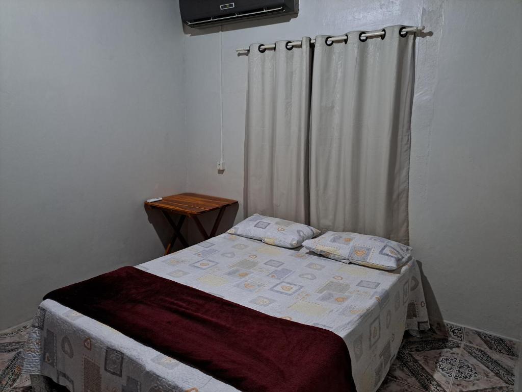 um pequeno quarto com uma cama com uma cortina em AP 2 - Apartamento Mobiliado Tamanho Família - Cozinha Completa em Macapá