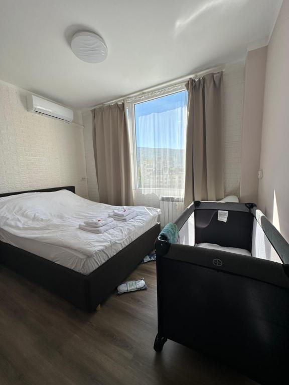niewielka sypialnia z łóżkiem i oknem w obiekcie Rose's apartment , self check-in, close to metro w mieście Sofia