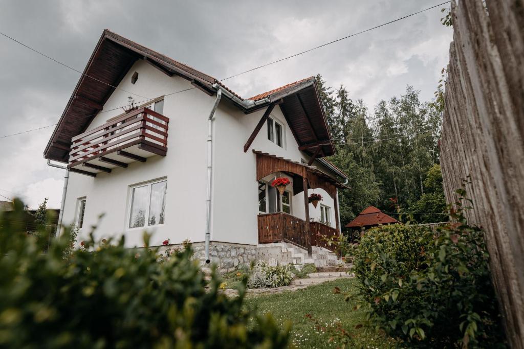 una casa bianca con un balcone sopra di Kaffai Panzio a Izvoru Mureşului