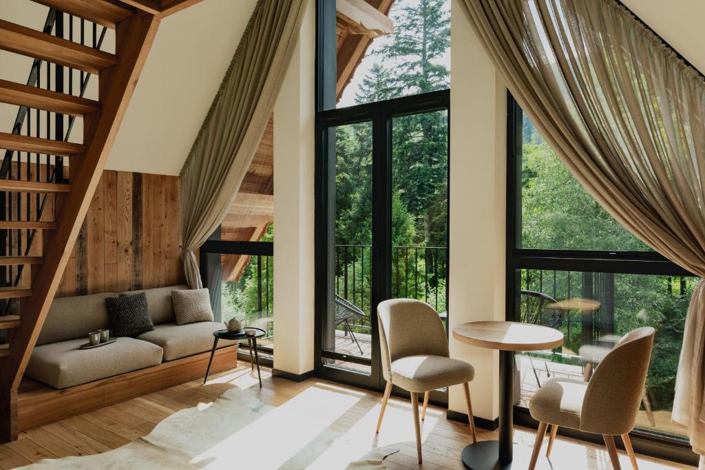 a living room with a couch and chairs and large windows at Stary Niedźwiedź in Zakopane