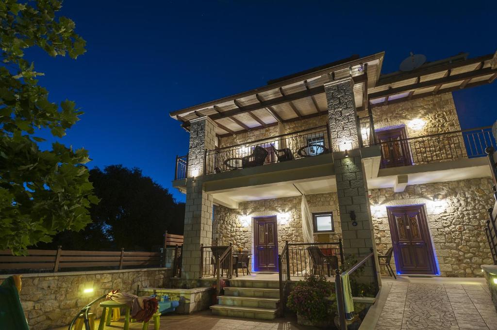 a stone house with blue doors and stairs at night at Fegaropetra studios in Sivota