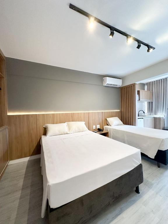 a hotel room with two beds and a kitchen at Flats em Brasília no Garvey Park Hotel in Brasília