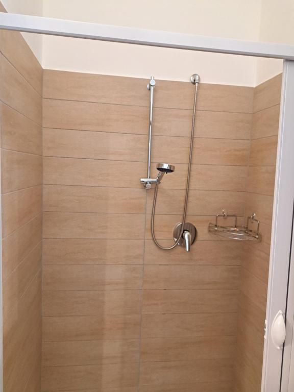 a shower with a wooden wall in a bathroom at La Foggia seaside paradise in Siculiana