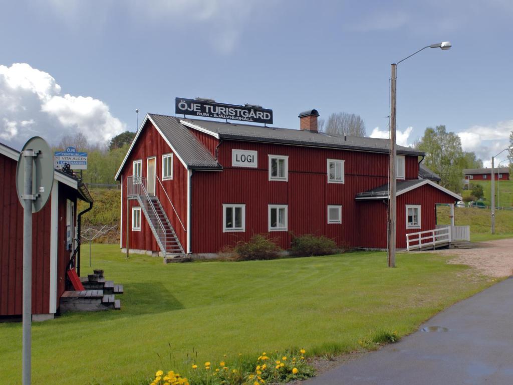 un granero rojo con un cartel encima en Öje Vandrarhem & Turistgård en Östra Öje