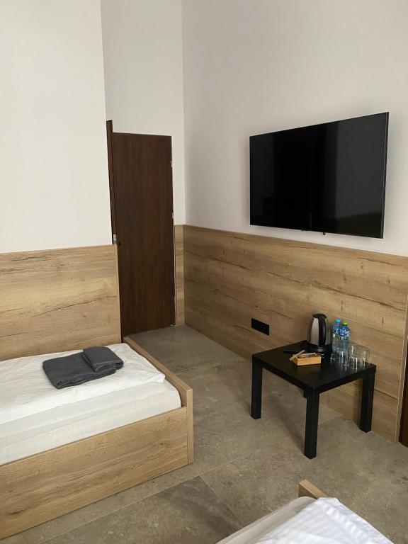 pokój z łóżkiem i stołem z telewizorem z płaskim ekranem w obiekcie Aparthotel Łódź 55 Piotrkowska w Łodzi