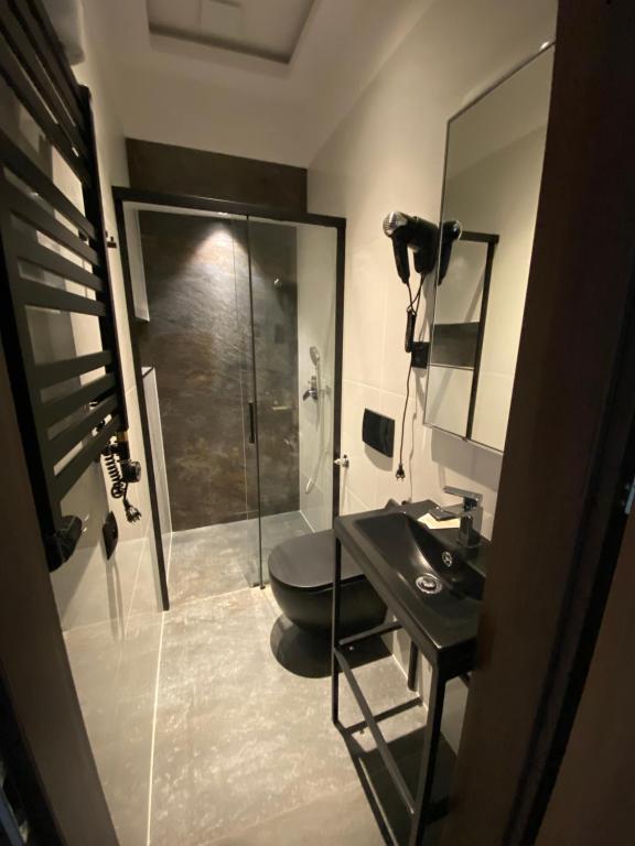 łazienka z prysznicem, umywalką i toaletą w obiekcie Aparthotel Łódź 55 Piotrkowska w Łodzi