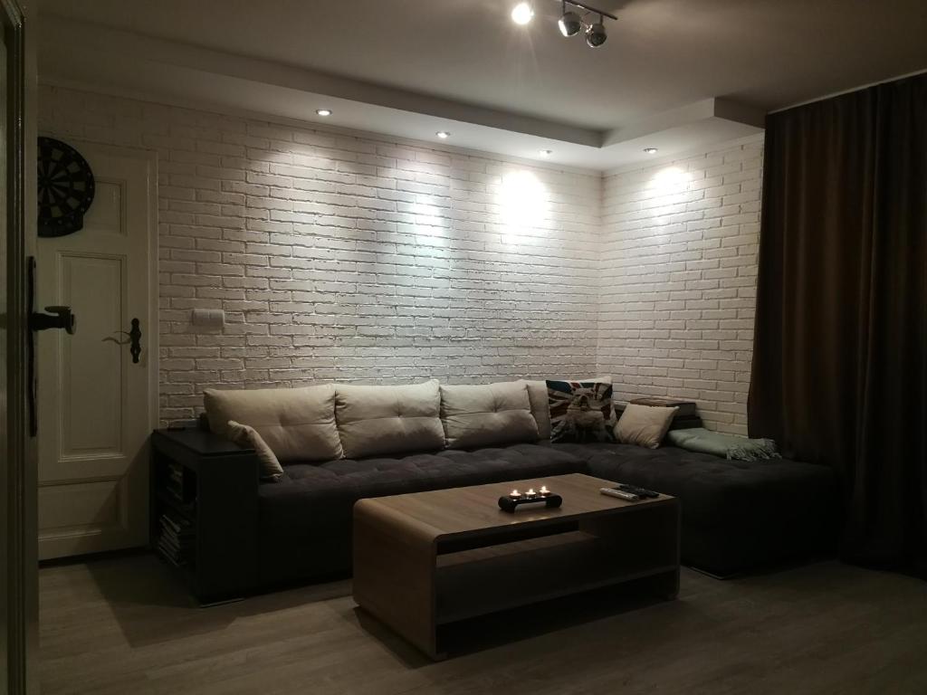 - un salon avec un canapé et un mur en briques dans l'établissement Къща за гости Casa Blanca, à Targovichté