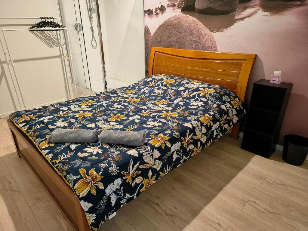 1 dormitorio con 1 cama con colcha azul y amarilla en Sky World Cozy Home, en Auckland
