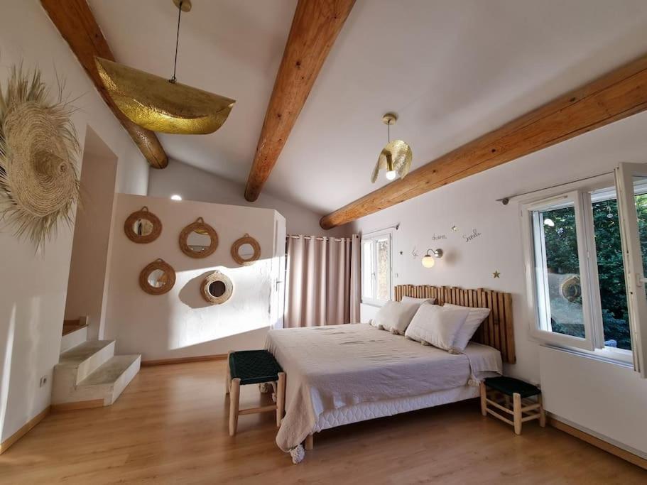 ein Schlafzimmer mit einem Bett in einem Zimmer mit Holzböden in der Unterkunft Maison de famille in Bouillargues