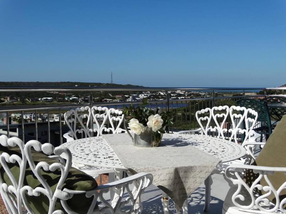 a white table and chairs with a view of the ocean at 14 at Karee in Stilbaai