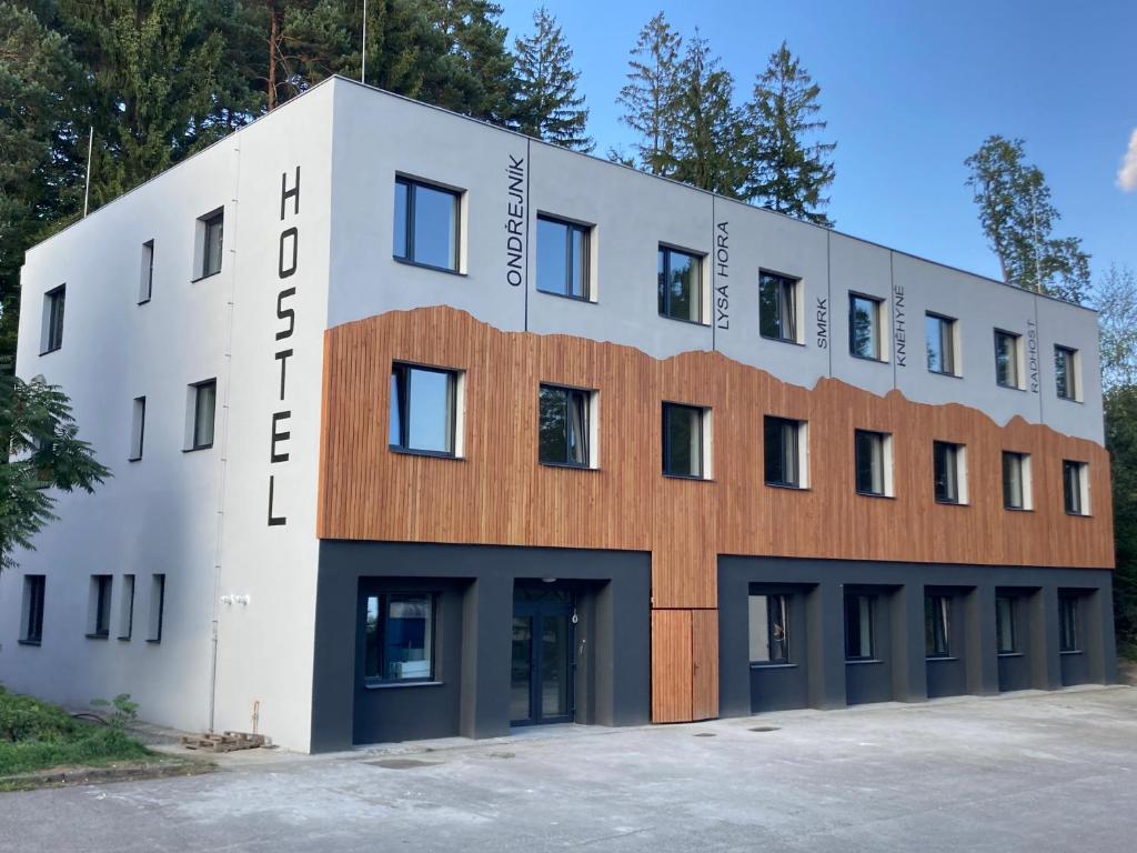 un grande edificio bianco con facciata in legno di Hostel Beskydy a Rožnov pod Radhoštěm