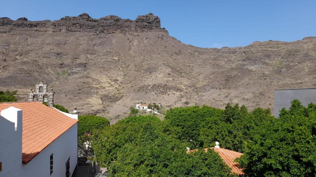 a mountain in the background with houses and trees at La Fortaleza House MOGAN in Mogán