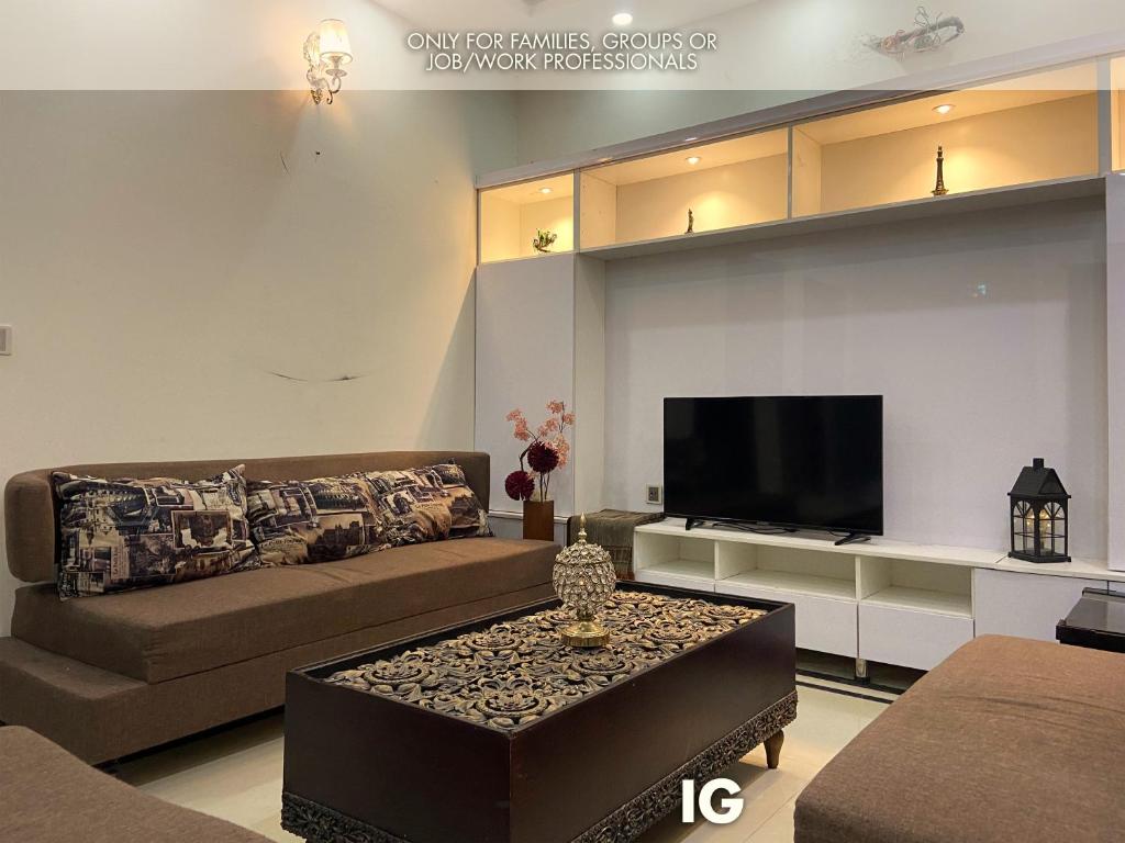 a living room with a couch and a tv at Furnished Luxury Holiday and Vacation Home in Lahore