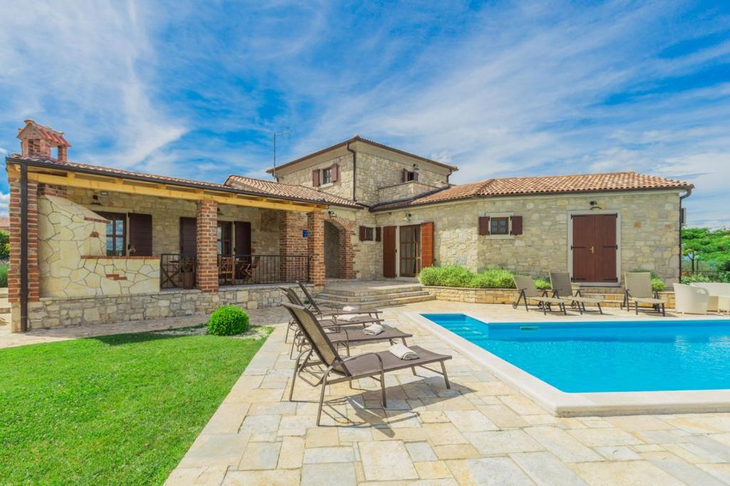 Villa con piscina frente a una casa en Villa Baldasera, en Vižinada