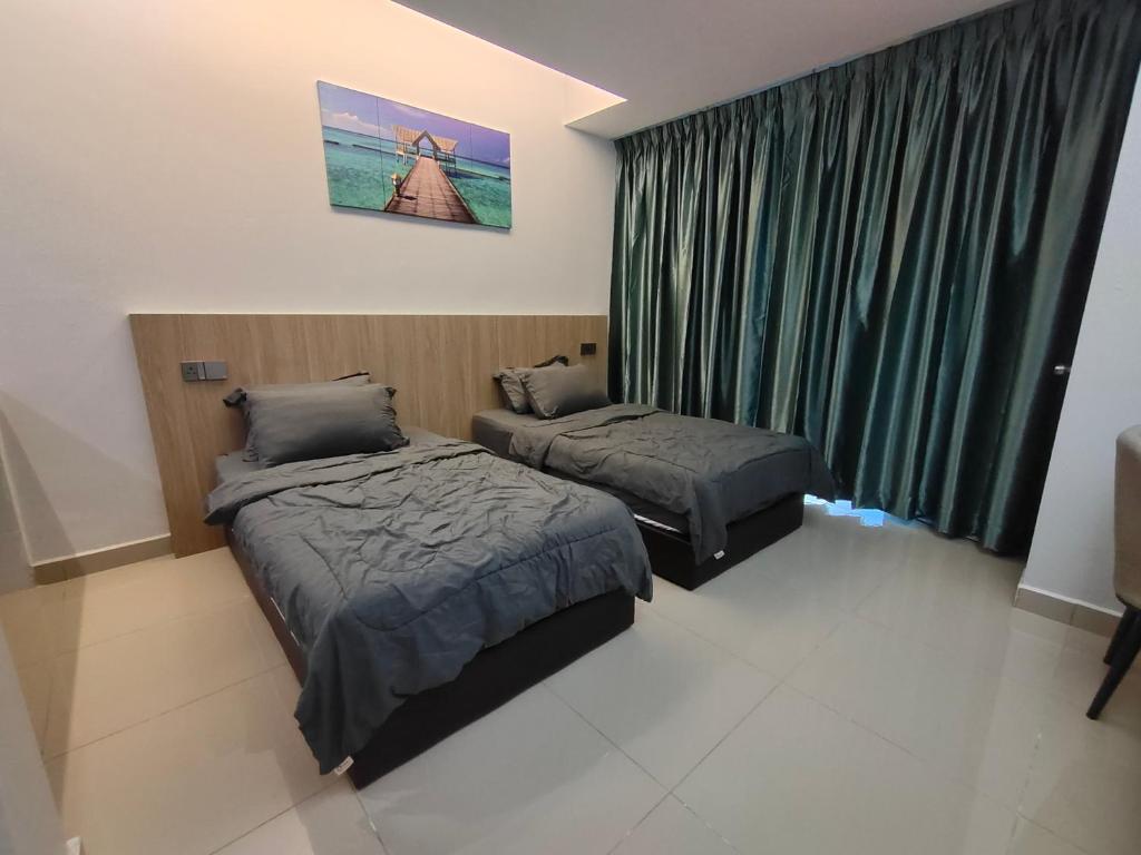 een slaapkamer met 2 bedden en een raam met groene gordijnen bij Hanan Studio Apartment with Pool, Wifi & Netflix in Gua Musang