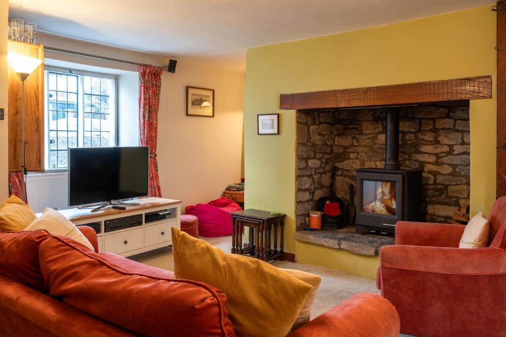 a living room with a couch and a fireplace at Finest Retreats - Clematis Cottage in Stogursey