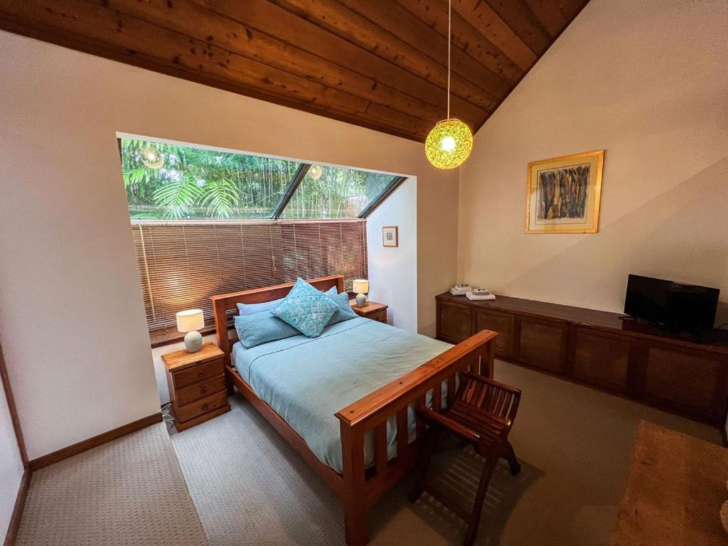 a bedroom with a bed and a large window at Lake Russell Retreat in Emerald Beach