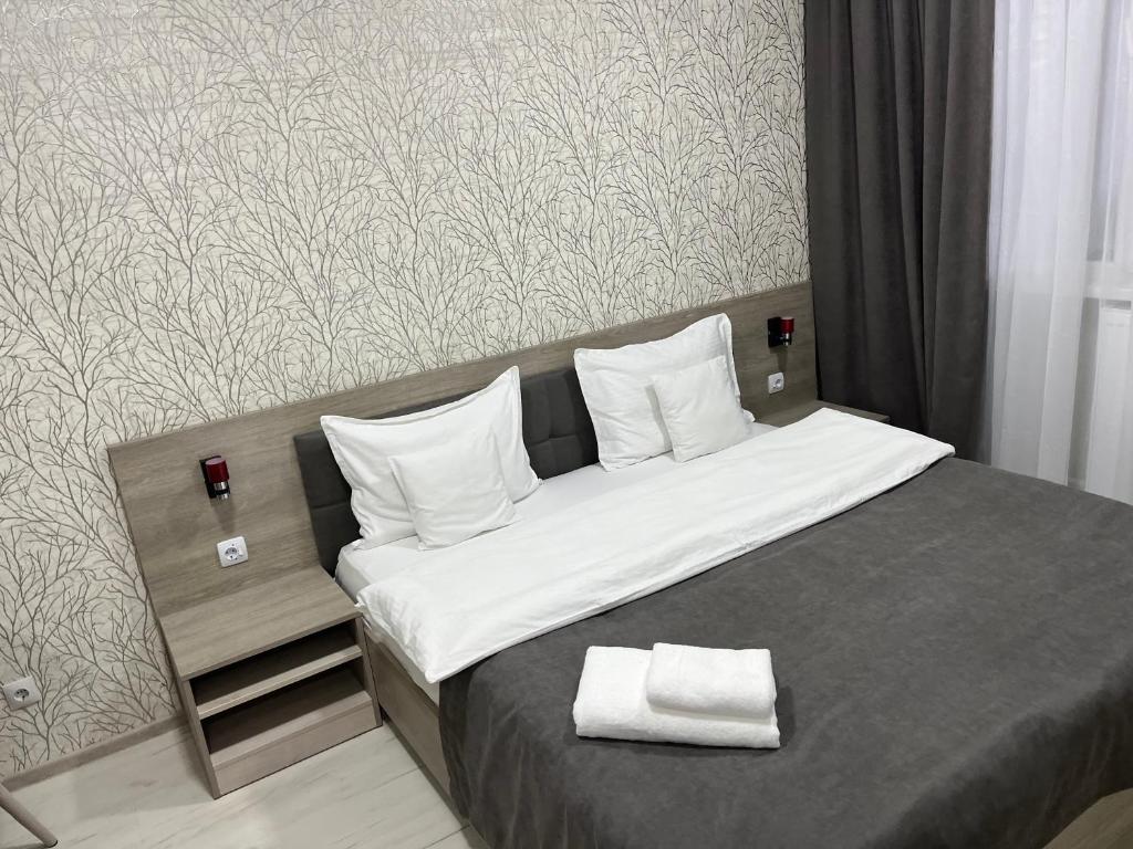 a bedroom with a large bed with white sheets and pillows at Apart Elite in Bălţi