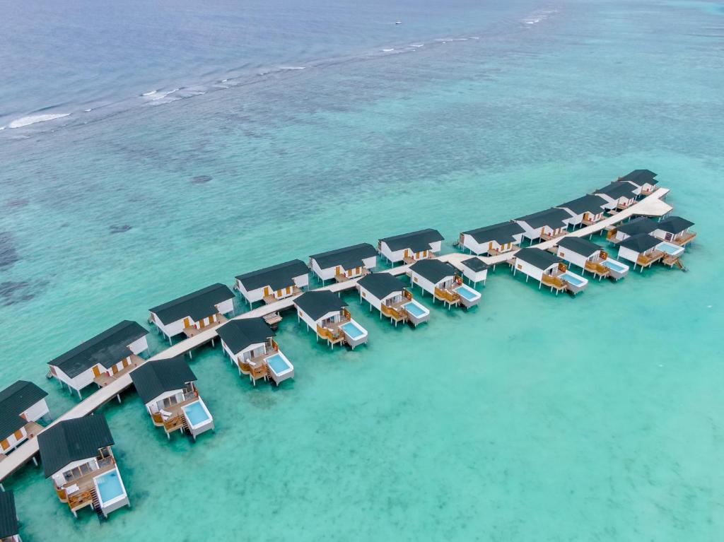 Vue de tête d'un groupe de tables sur l'eau dans l'établissement Joy Island Maldives All Inclusive Resort, à Malé