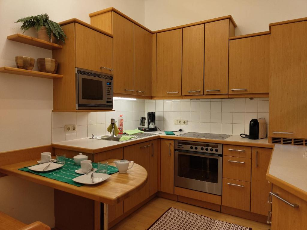 a kitchen with wooden cabinets and a table with cups on it at Altstadtparee in Steyr