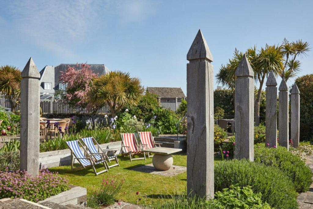 a group of chairs and a bench in a garden at Wentworth Hotel in Aldeburgh