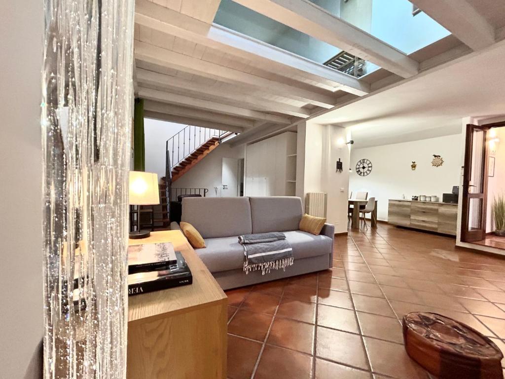 ein Wohnzimmer mit einem Sofa und einem Tisch in der Unterkunft SUNFLOWER APARTMENT in Peschiera del Garda