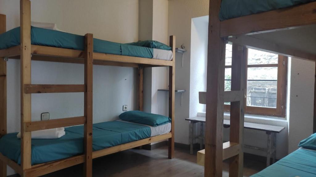 a room with two bunk beds and a window at Albergue Tritón - Villanúa in Villanúa