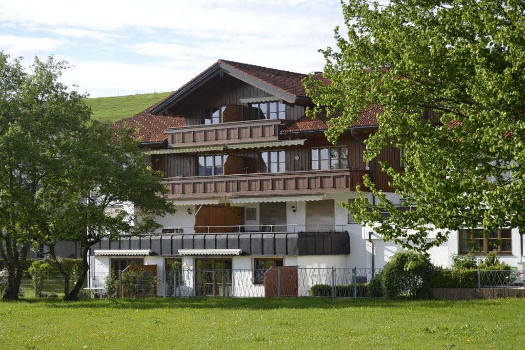 un gran edificio blanco con árboles delante de él en Ferienwohnung Himmel, en Oberstaufen