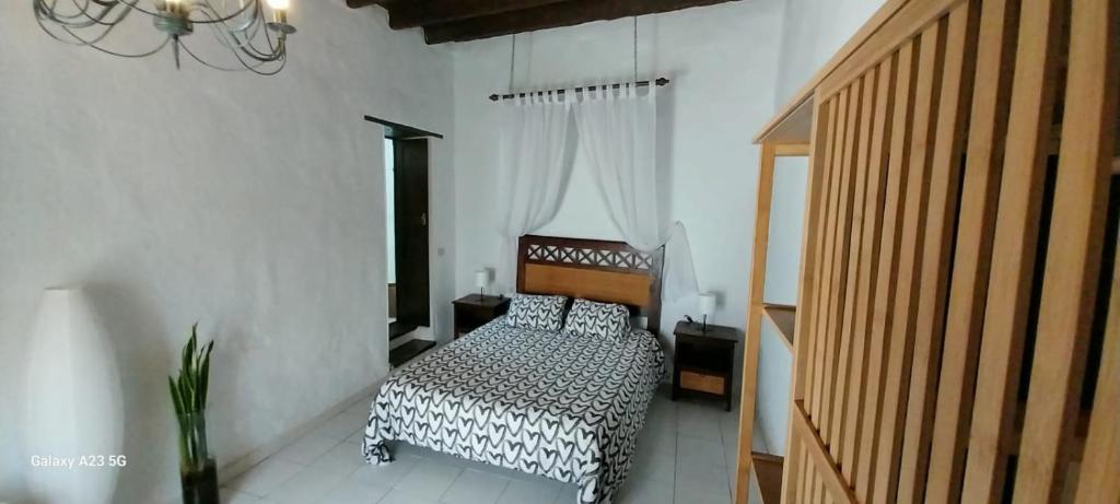 ein Schlafzimmer mit einem Bett mit einer schwarzen und weißen Decke in der Unterkunft Suite casa rural Los Patios, CONIL in Tías