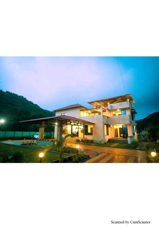 a building with lights in a parking lot at night at Coconut Villa in Malavli