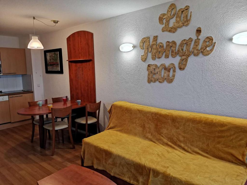 a living room with a couch and a dining room table at Charmant T2 à La Mongie - Terrasse, Piscine Couverte, Salle de Fitness, Proche Pistes - FR-1-404-270 in La Mongie