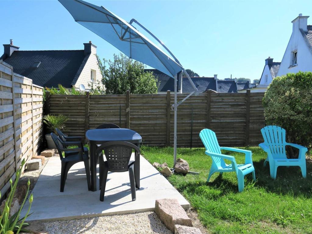un groupe de chaises et une table dans une arrière-cour dans l'établissement Maison renovée avec jardin, WiFi, à 1km du port de Ploumanac'h, Perros-Guirec - FR-1-368-303, à Perros-Guirec
