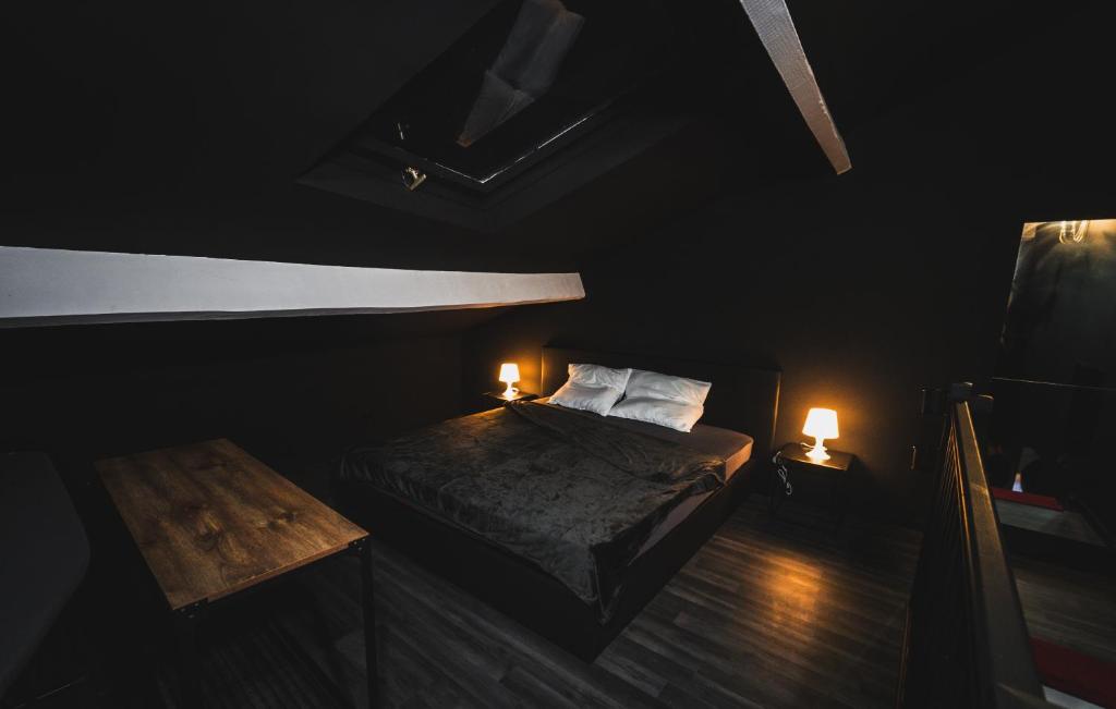 a dark room with a bed and two lamps at Amour d&#39;une Nuit, LoveRoom in Sarcelles