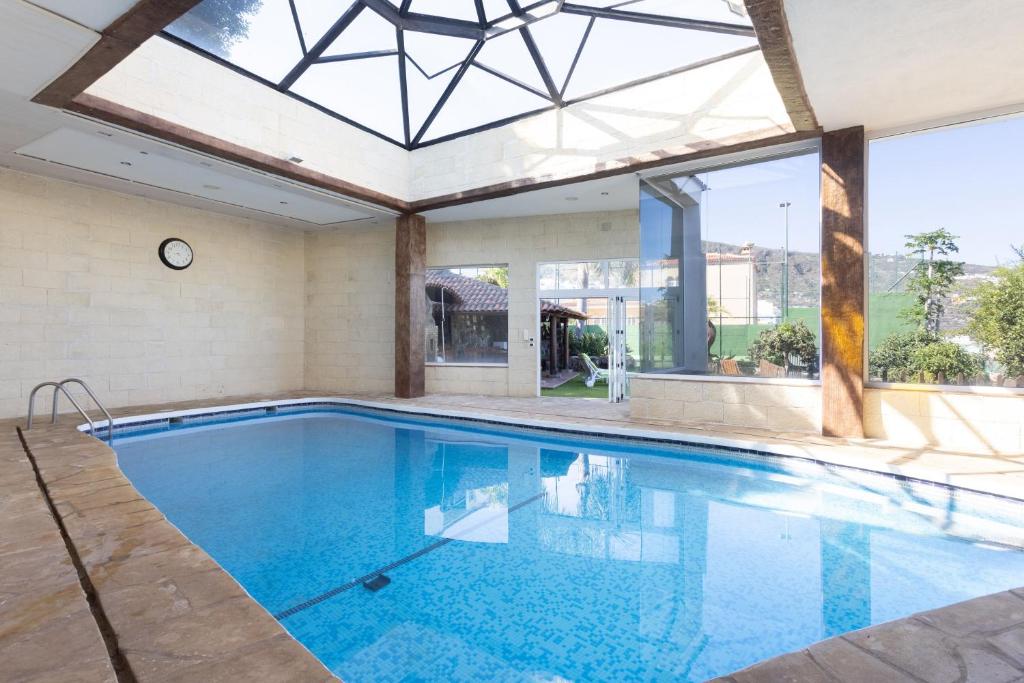 - une piscine intérieure avec une lucarne dans une maison dans l'établissement Casa Los Grabados, piscina, vistas, barbacoa y zen, à Icod de los Vinos