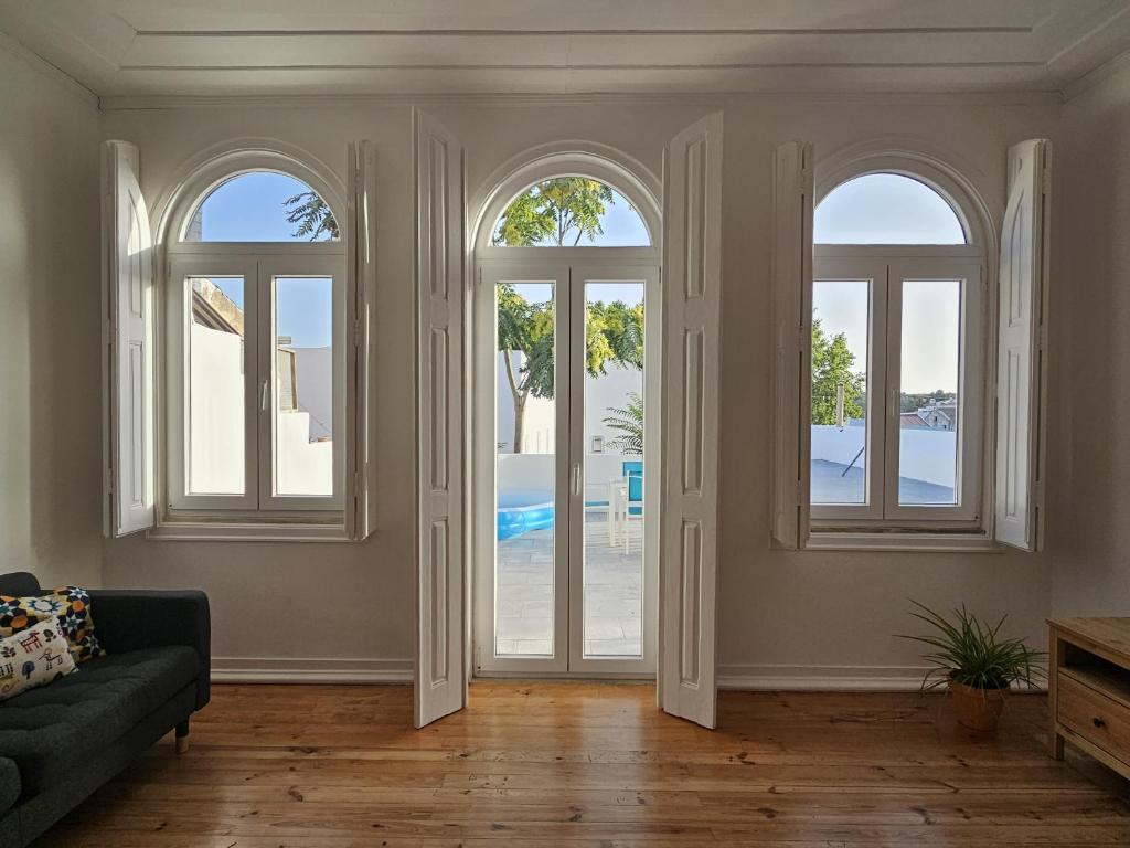 a living room with arched windows and a couch at Casa Semedo in Montemor-o-Novo
