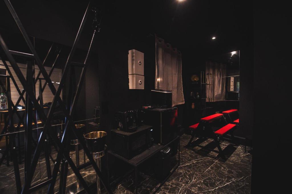 a dark room with a red chair and a mirror at Amour d&#39;une Nuit, LoveRoom in Sarcelles