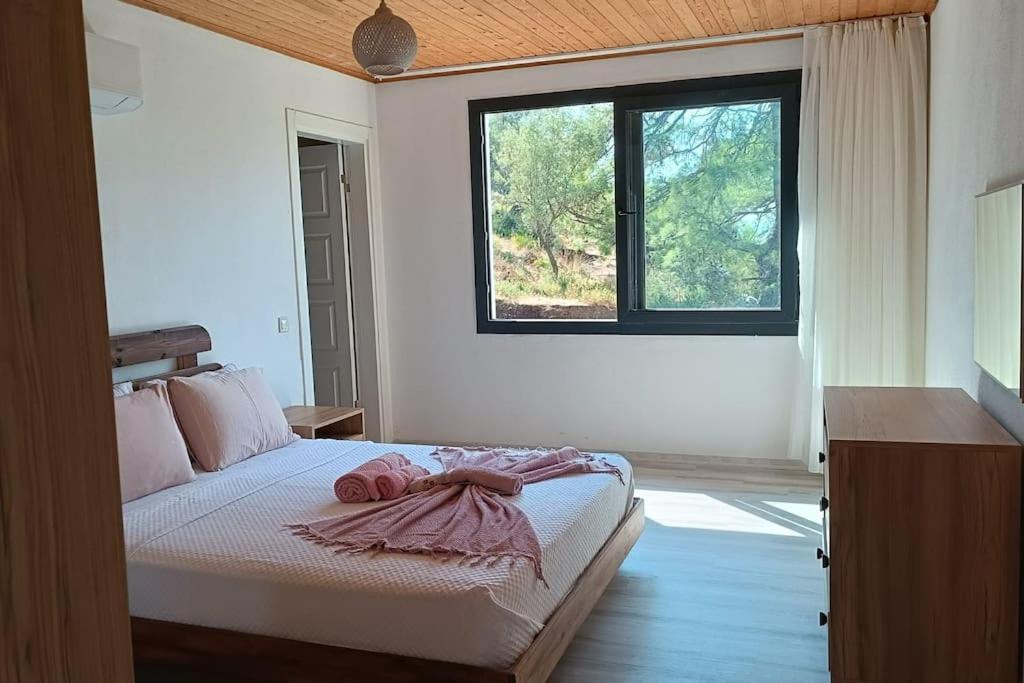 a bedroom with a large bed with a window at House of Joy in Marmaris