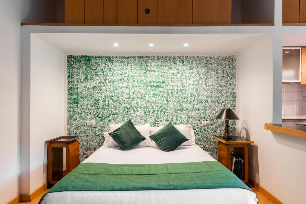 a bedroom with a bed with a green wall at Studio Suite Aurelia Antica in Rome