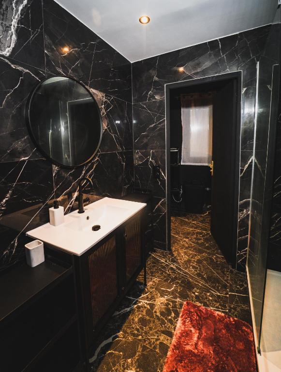 a bathroom with a sink and a mirror at Amour d&#39;une Nuit, LoveRoom in Sarcelles