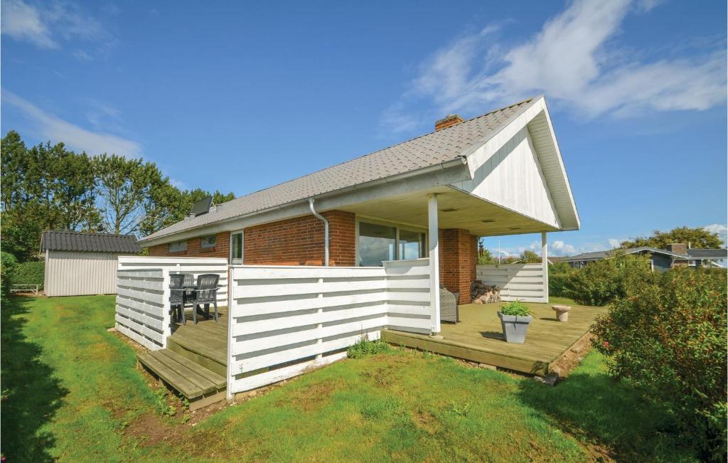 una pequeña casa con una valla blanca en un patio en 3 Bedroom Amazing Home In Hurup Thy, en Doverodde