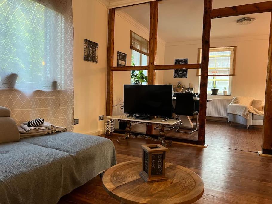 a living room with a bed and a television at Sandys Cozy Stone Cottage in Maulbronn