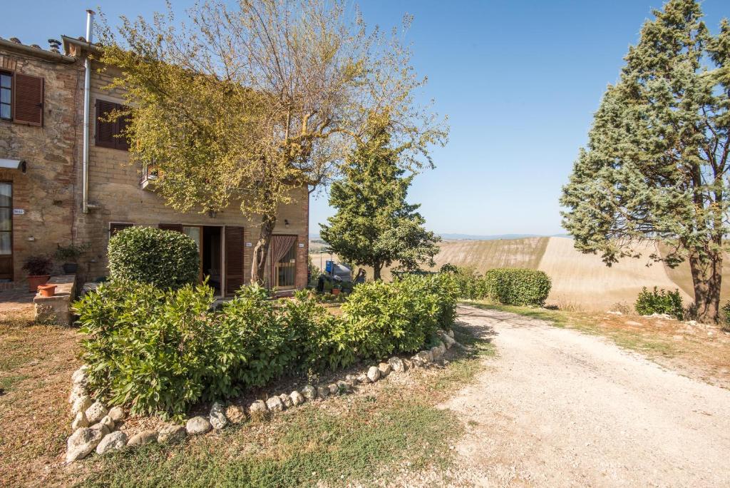 uma casa com árvores e uma estrada de terra em La Casina di Radi em Monteroni dʼArbia